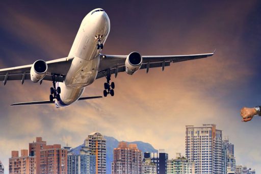 Man checking his watch with a departing airplane about to fly over him