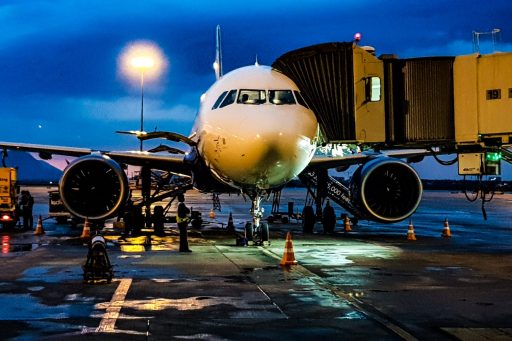 Delayed aircraft parked at gate against darkening sky background.