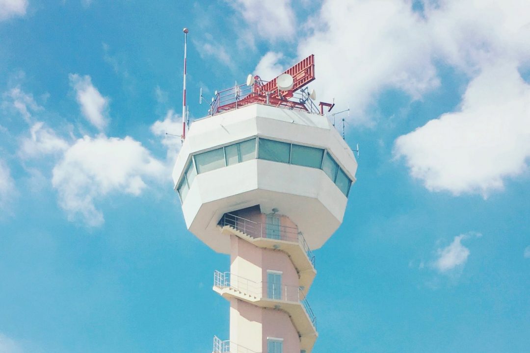 Air traffic control tower against sky background at airport