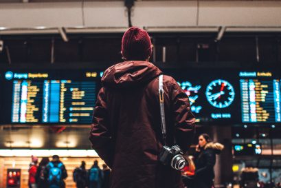 tourist with camera looking at delayed and canceled flights